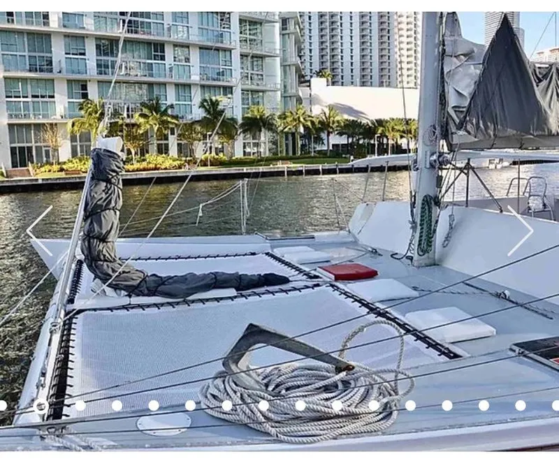 Slide: The Image of 1987 Custom Suncoast Catamaran docked near modern waterfront buildings. - 5