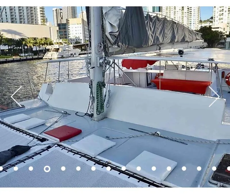 Slide: The Image of 1987 Custom Suncoast Catamaran docked in a marina with cityscape background. - 7
