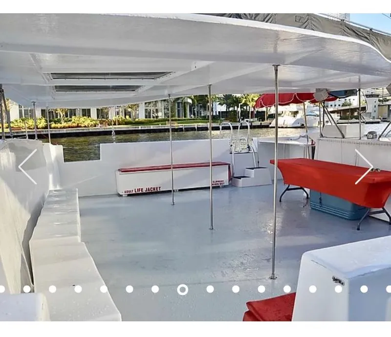 Slide: The Image of 1987 Custom Suncoast Catamaran deck with seating, life jacket storage, and waterfront view. - 8