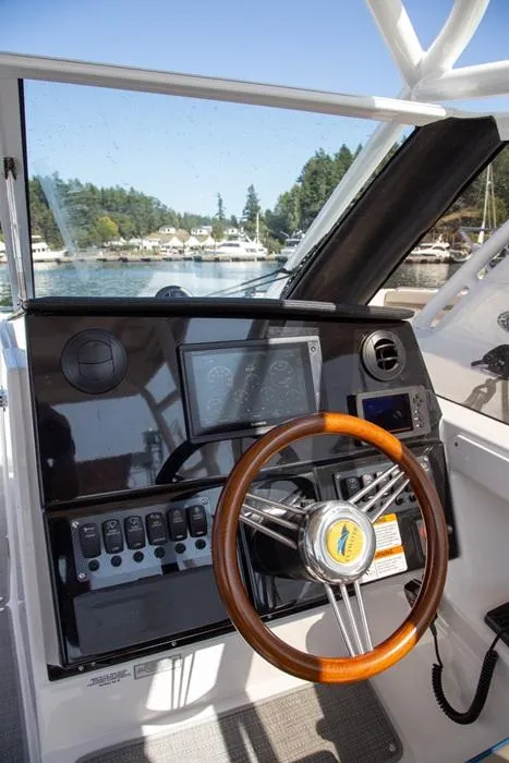 Slide: The Image of 2020 Cutwater 24 DC boat dashboard with wooden steering wheel and modern controls. - 10