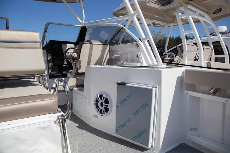 Slide: The Image of 2020 Cutwater 24 DC Dual Console boat interior with beige seating and modern amenities. - 15