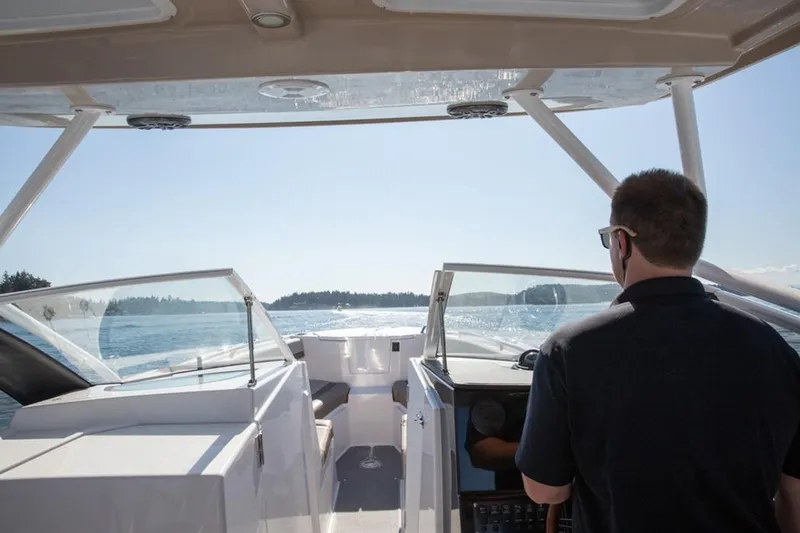 Slide: The Image of Man steering 2020 Cutwater 24 DC boat on open water. - 3