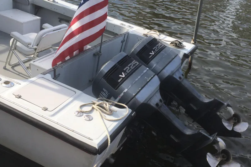 Slide: The Image of 1987 Boston Whaler Cuddy Tower with twin V225 engines and American flag on water. - 3