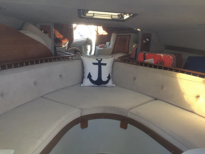 Slide: The Image of 1987 Boston Whaler Cuddy Tower interior with anchor-themed pillow and cushioned seating. - 5