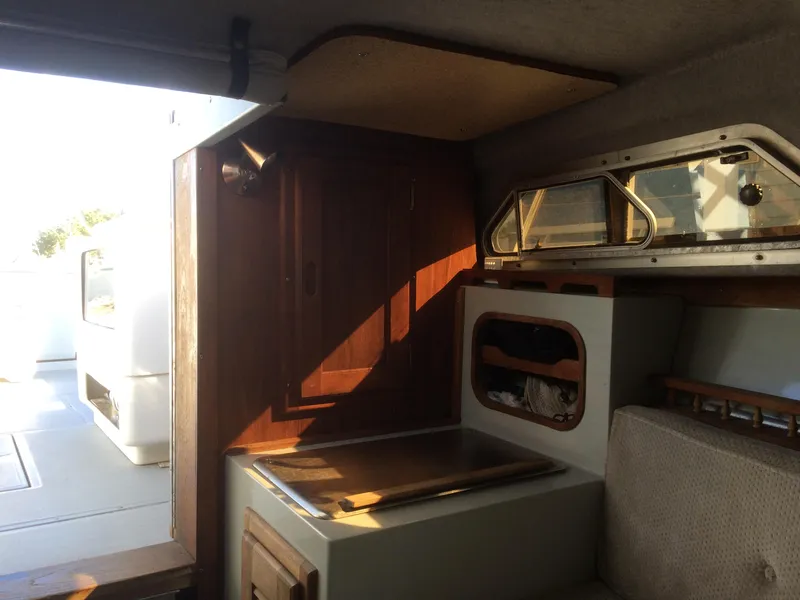 Slide: The Image of Interior of a 1987 Boston Whaler Cuddy Tower boat, featuring wood accents and compact design. - 6