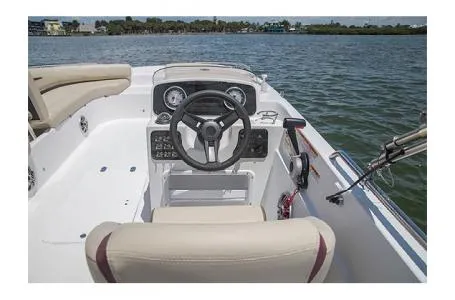 Slide: The Image of 2017 Hurricane SS 201 boat interior with steering wheel, dashboard, and seating on calm water. - 13