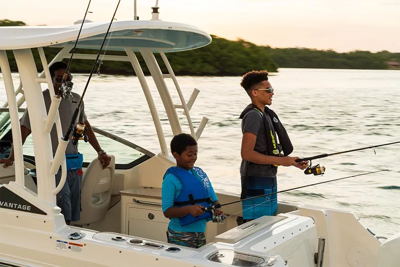 Slide: The Image of Family fishing on a 2023 Boston Whaler 240 Vantage boat at sunset. - 24