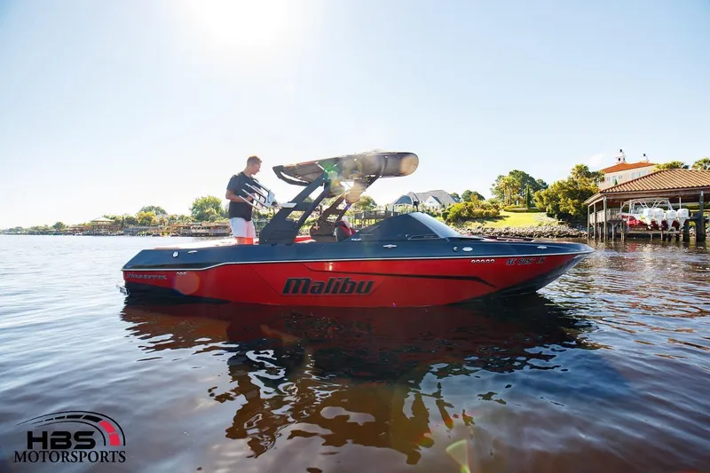 Slide: The Image of 2019 Malibu Wakesetter 25 LSV boat on a sunny lake near a dock. - 4