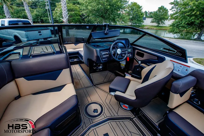 Slide: The Image of 2020 Moomba Kaiyen boat interior with tan and black seating, steering console, and dashboard. - 6