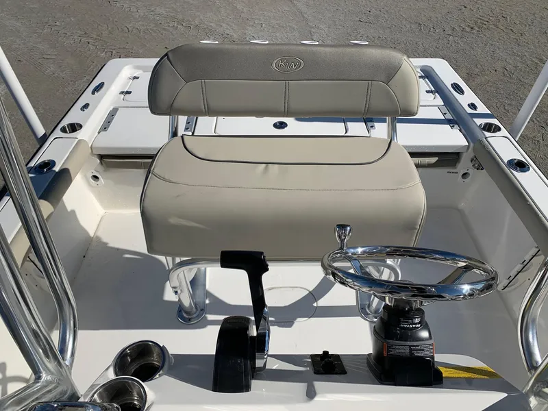 Slide: The Image of 2024 Key West 210 Bay Reef boat interior with steering wheel and seating. - 11