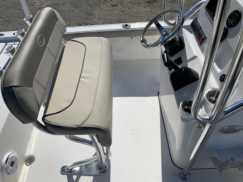 Slide: The Image of 2024 Key West 210 Bay Reef boat interior with steering console and cushioned seating. - 12