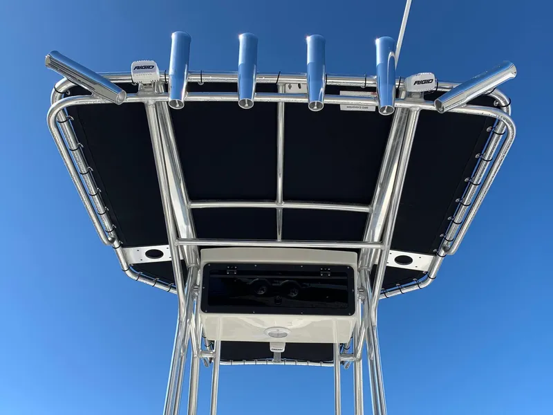 Slide: The Image of 2024 Key West 210 Bay Reef T-top with rod holders against blue sky. - 4