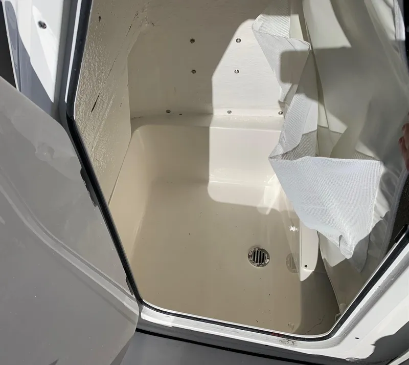 Slide: The Image of 2024 Key West 210 Bay Reef storage compartment with drain. - 7