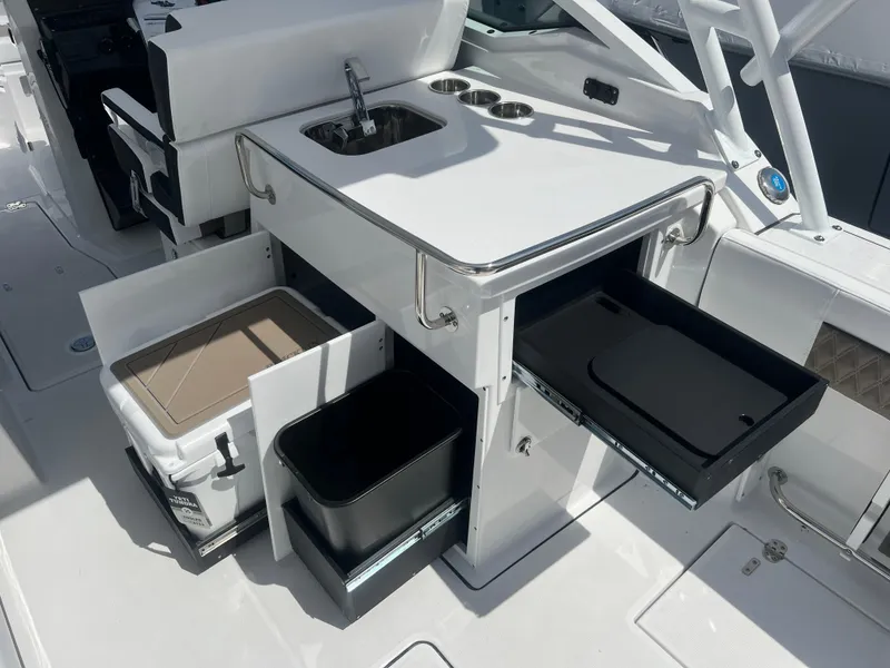 Slide: The Image of 2024 Blackfin 272DC boat with open storage compartments and sink. - 14