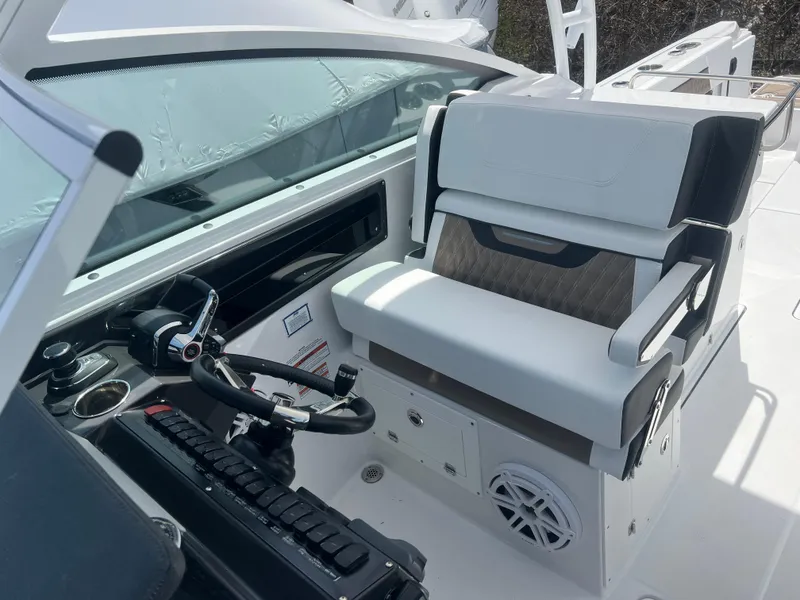 Slide: The Image of 2024 Blackfin 272DC boat cockpit with steering wheel and cushioned seating. - 20