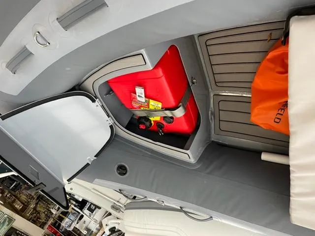 Slide: The Image of Storage compartment of 2024 Highfield Classic 310 boat with red fuel tank and orange bag. - 13