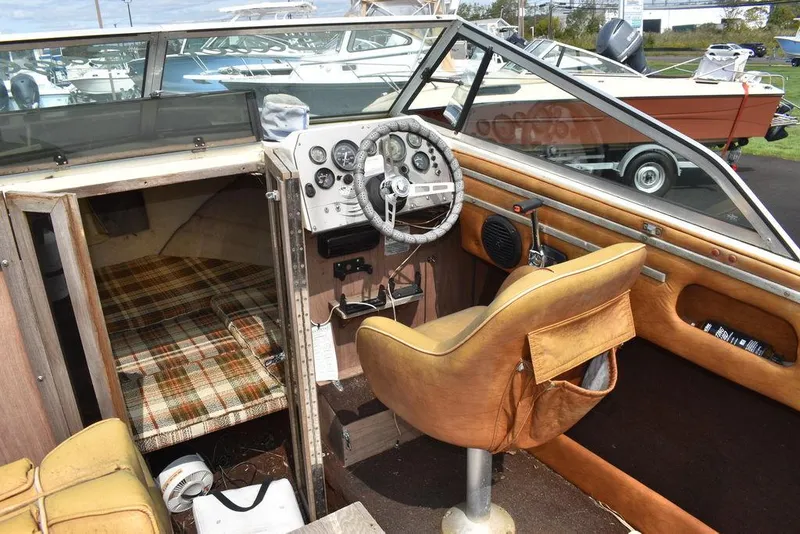 Slide: The Image of 1983 Rinker 204 Cuddy Cabin interior with steering wheel and plaid cabin bed. - 5