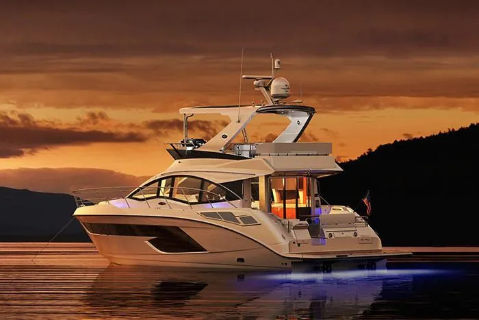 Slide: The Image of 2018 Sea Ray Fly 520 yacht at sunset on calm waters. - 2