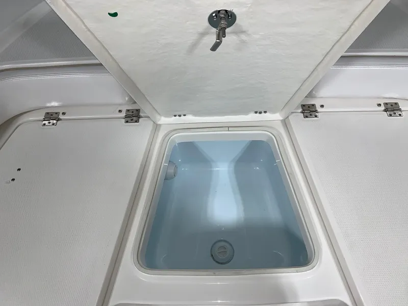 Slide: The Image of Livewell compartment on 2026 Robalo 226 Cayman boat, open lid view. - 25