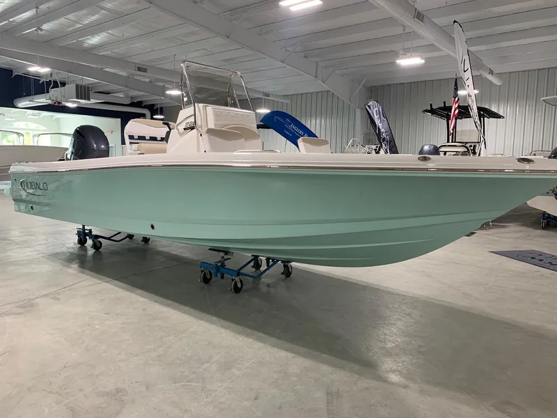 Slide: The Image of 2026 Robalo 226 Cayman boat displayed indoors, showcasing sleek design and mint green hull. - 4