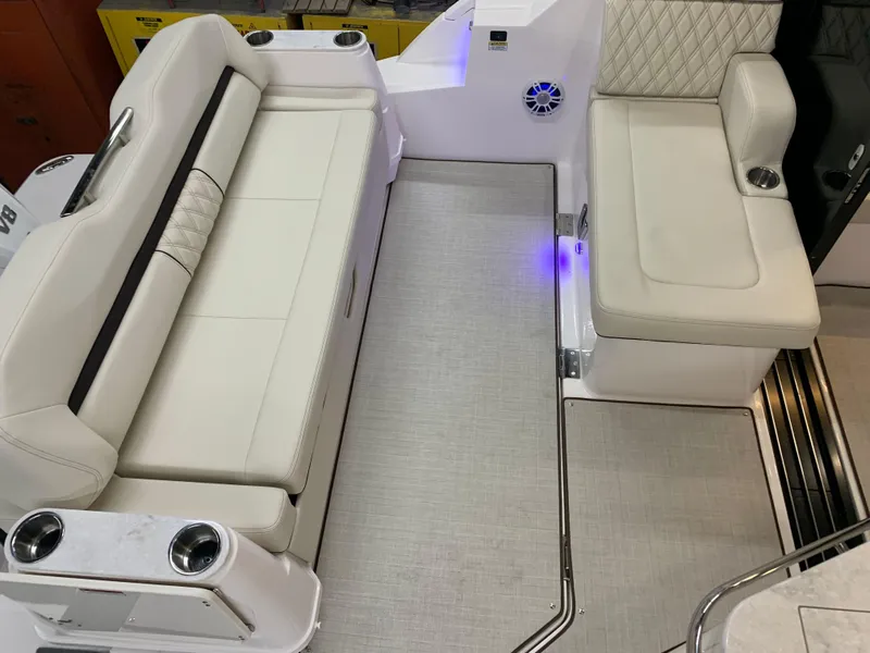Slide: The Image of 2023 Regal 36XO boat interior with white leather seating and cup holders. - 2