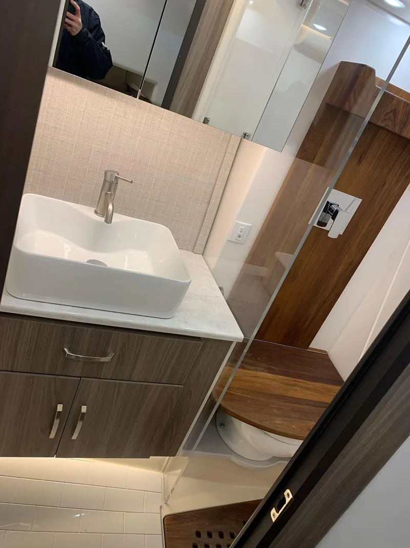 Slide: The Image of Modern bathroom in 2023 Regal 36XO yacht with sleek sink and wooden accents. - 25
