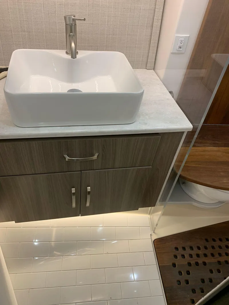 Slide: The Image of Modern bathroom vanity in 2023 Regal 36XO yacht with vessel sink and wood cabinetry. - 27