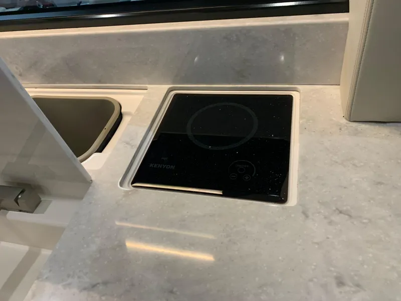 Slide: The Image of Modern kitchen countertop with built-in Kenyon cooktop on 2023 Regal 36XO yacht. - 9