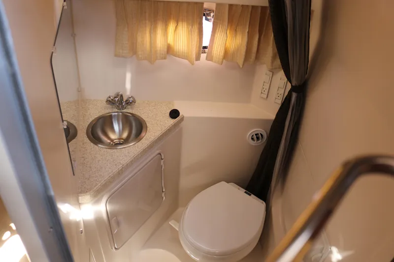 Slide: The Image of 2009 Regal 3060 Express Cruiser bathroom with sink, toilet, and curtain. - 13