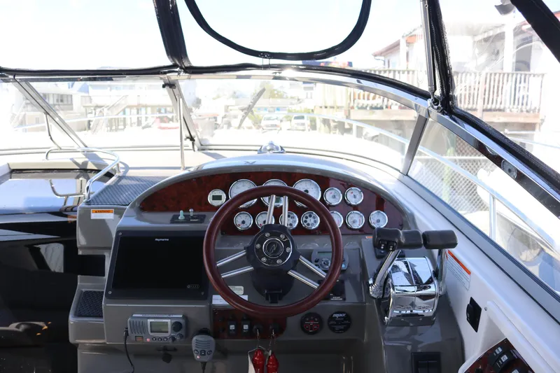 Slide: The Image of 2009 Regal 3060 Express Cruiser helm with gauges, steering wheel, and navigation equipment. - 6