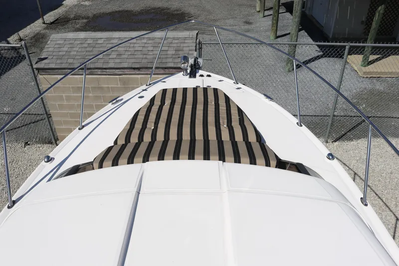 Slide: The Image of 2009 Regal 3060 Express Cruiser boat with striped deck cushion, docked in a marina. - 7