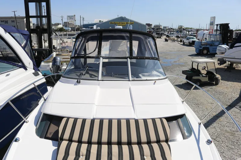 Slide: The Image of 2009 Regal 3060 Express Cruiser docked at a marina, featuring striped seating. - 9