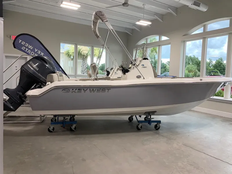 Slide: The Image of 2024 Key West 189 FS boat displayed indoors with Yamaha outboard motor. - 0