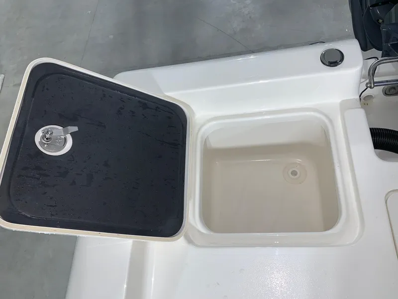 Slide: The Image of Key West 188 Bay Reef 2026 boat compartment with open lid, showcasing storage space. - 8