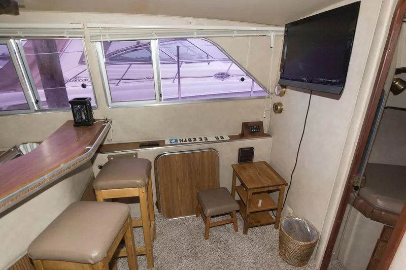 Slide: The Image of Interior of 1984 Chris-Craft 350 Catalina yacht with seating, table, and mounted TV. - 12