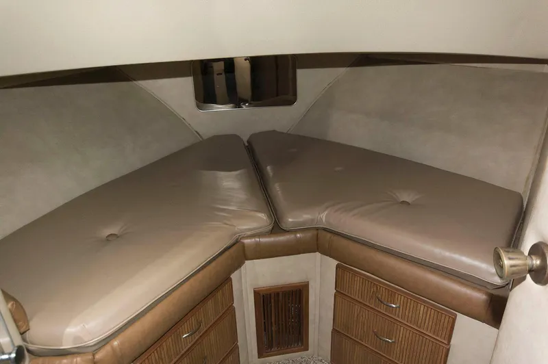Slide: The Image of 1984 Chris-Craft 350 Catalina cabin interior with beige cushions and wooden storage drawers. - 14