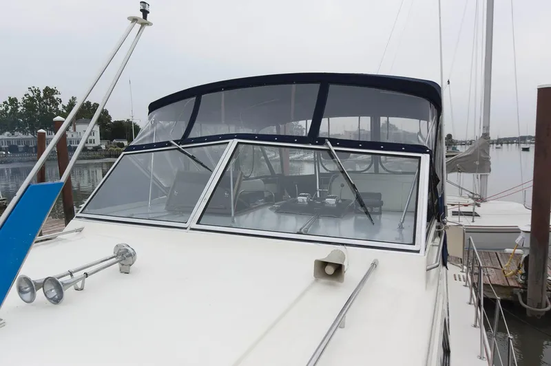 Slide: The Image of 1984 Chris-Craft 350 Catalina yacht with blue canopy docked at marina. - 2