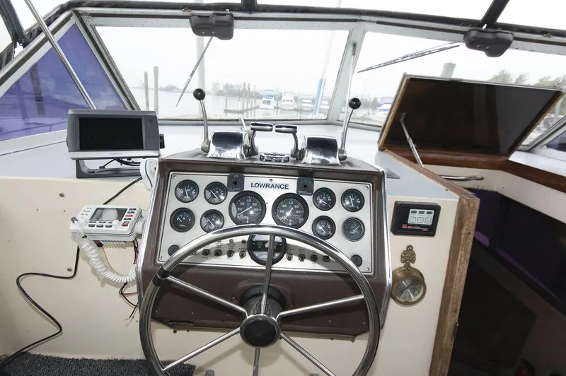 Slide: The Image of 1984 Chris-Craft 350 Catalina boat dashboard with steering wheel and navigation instruments. - 7