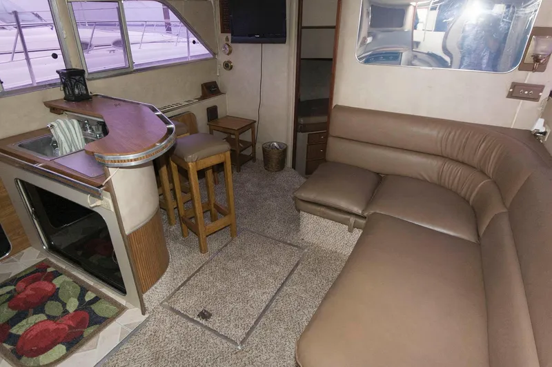 Slide: The Image of 1984 Chris-Craft 350 Catalina interior with bar, seating, and carpeted floor. - 9