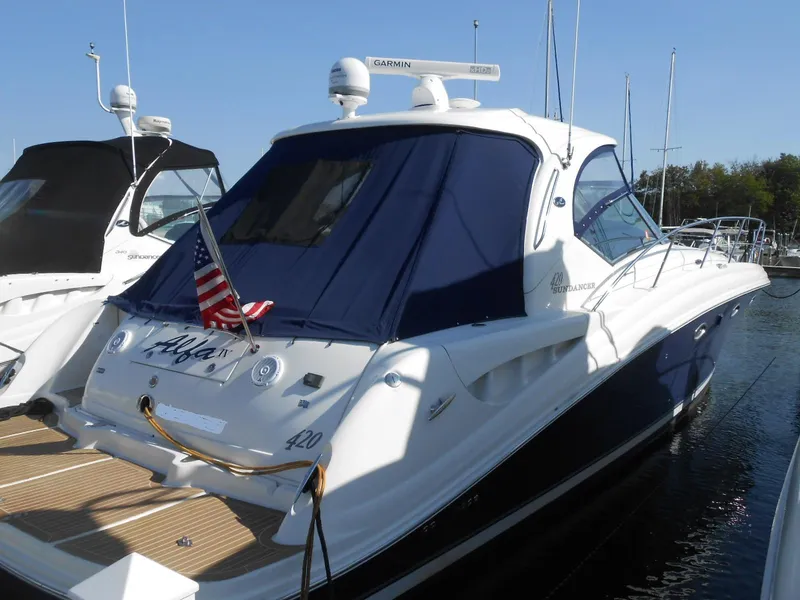 The Image of 2005 Sea Ray 420 Sundancer yacht docked, featuring a sleek design and American flag. - 0
