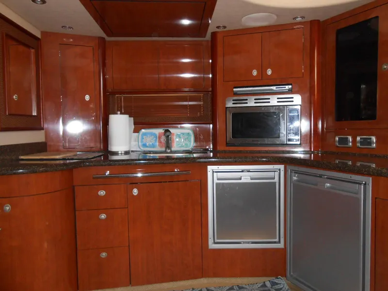 Slide: The Image of Luxurious kitchen interior of 2005 Sea Ray 420 Sundancer yacht with wood cabinetry and modern appliances. - 15