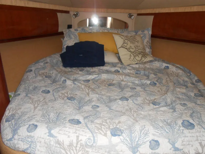 Slide: The Image of Cozy cabin interior of 2005 Sea Ray 420 Sundancer with nautical-themed bedding. - 18