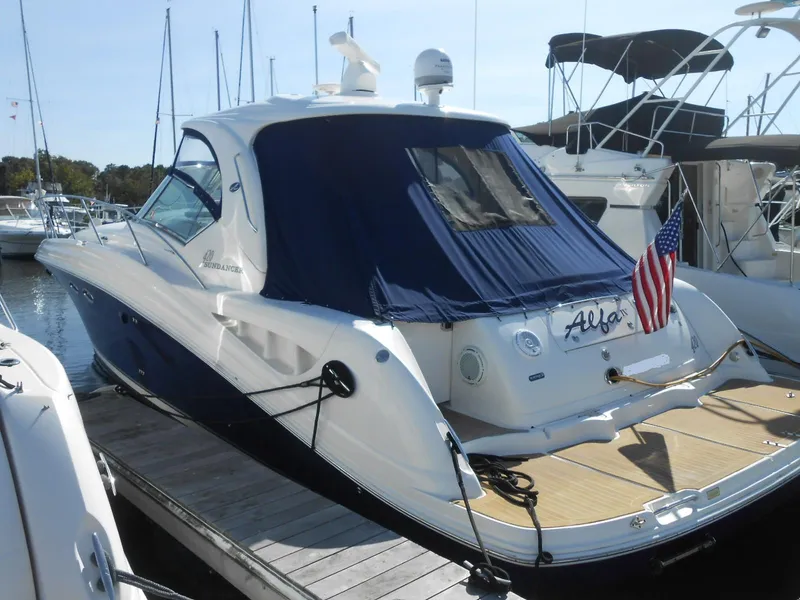 Slide: The Image of 2005 Sea Ray 420 Sundancer yacht docked with blue cover and American flag. - 3