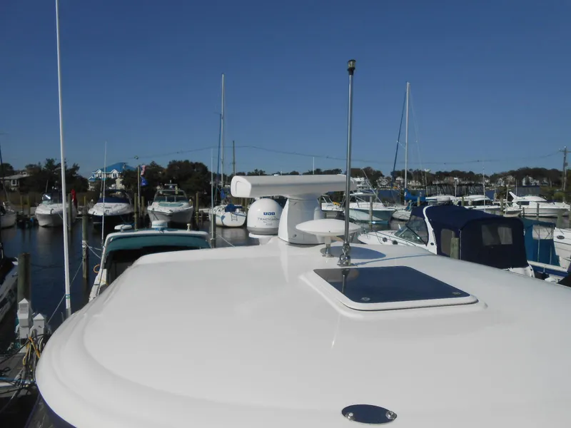 Slide: The Image of 2005 Sea Ray 420 Sundancer yacht docked in a marina under clear blue skies. - 8