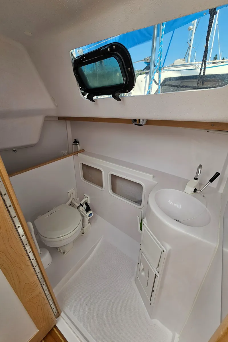 Slide: The Image of 2015 Catalina 275 Sport boat interior with compact bathroom, featuring toilet and sink. - 6