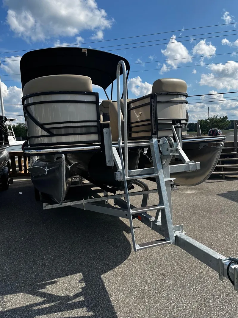 Slide: The Image of 2024 Starcraft SLS 3 pontoon boat on a trailer under a blue sky. - 4