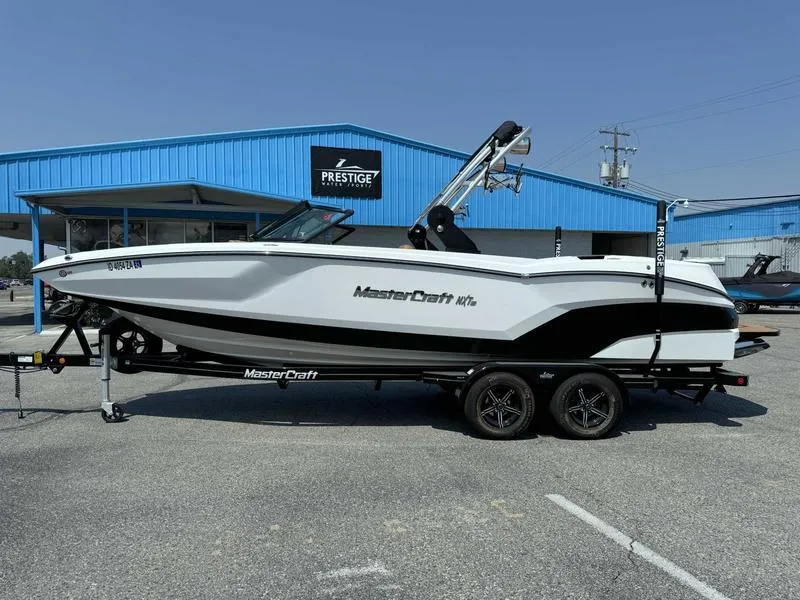 Slide: The Image of 2021 MasterCraft NXT24 boat on trailer in front of Prestige dealership. - 1