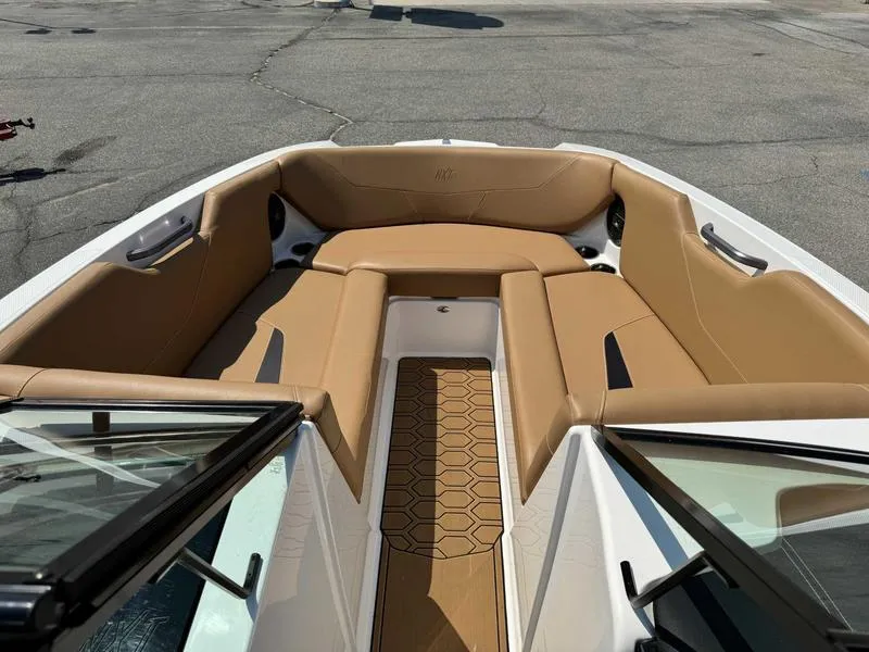 Slide: The Image of 2021 MasterCraft NXT24 boat with tan interior seating and hexagonal floor pattern. - 9