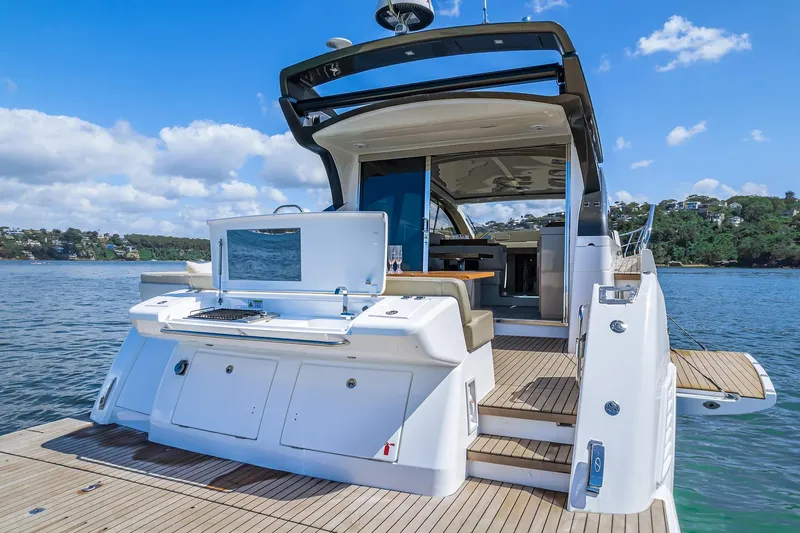 Slide: The Image of 2025 Schaefer 510 Sport yacht with open deck and scenic water view. - 11