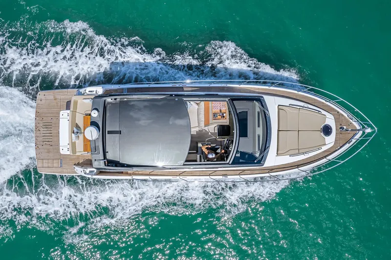 Slide: The Image of Aerial view of 2025 Schaefer 510 Sport yacht cruising on turquoise water. - 2